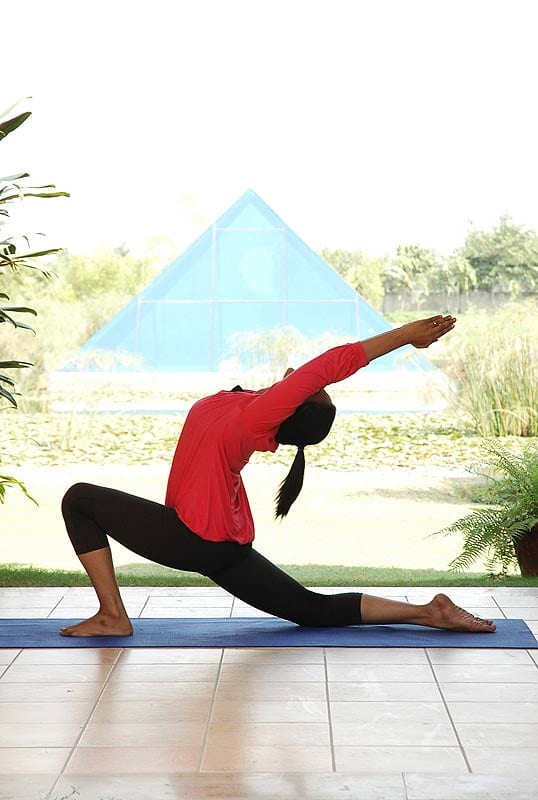 Yogacharya Deeksha Jain in Anjeneya Asana. This posture relieves back pain; helps to stretch both the upper and lower back;, releasing pent up tension due to long hours of sitting and working on the computer; makes the spine more supple, tones and strengthens the hips and thighs, and develops concentration and balance