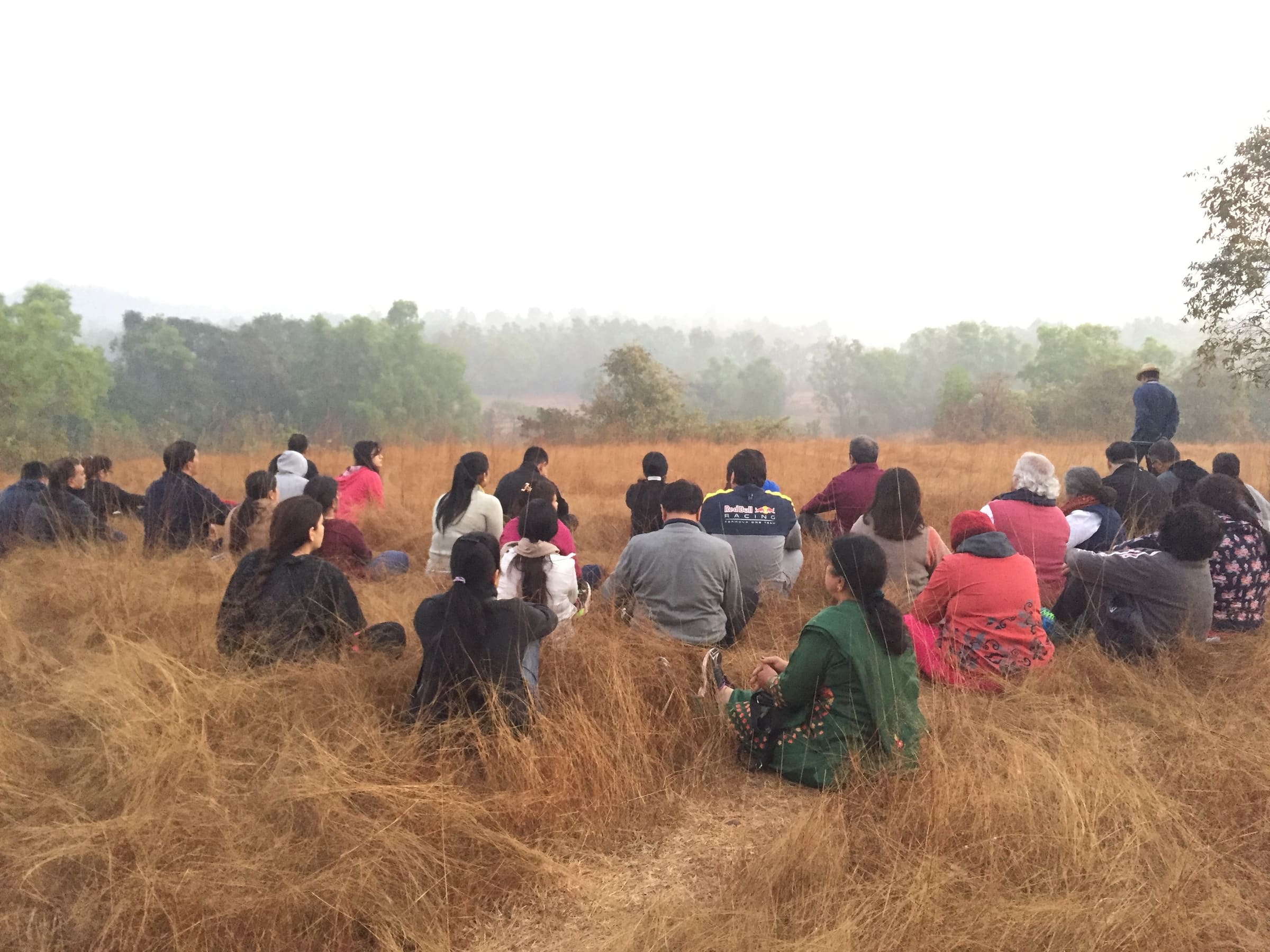 Retreat group sitting together in a meadow with the western ghats behind